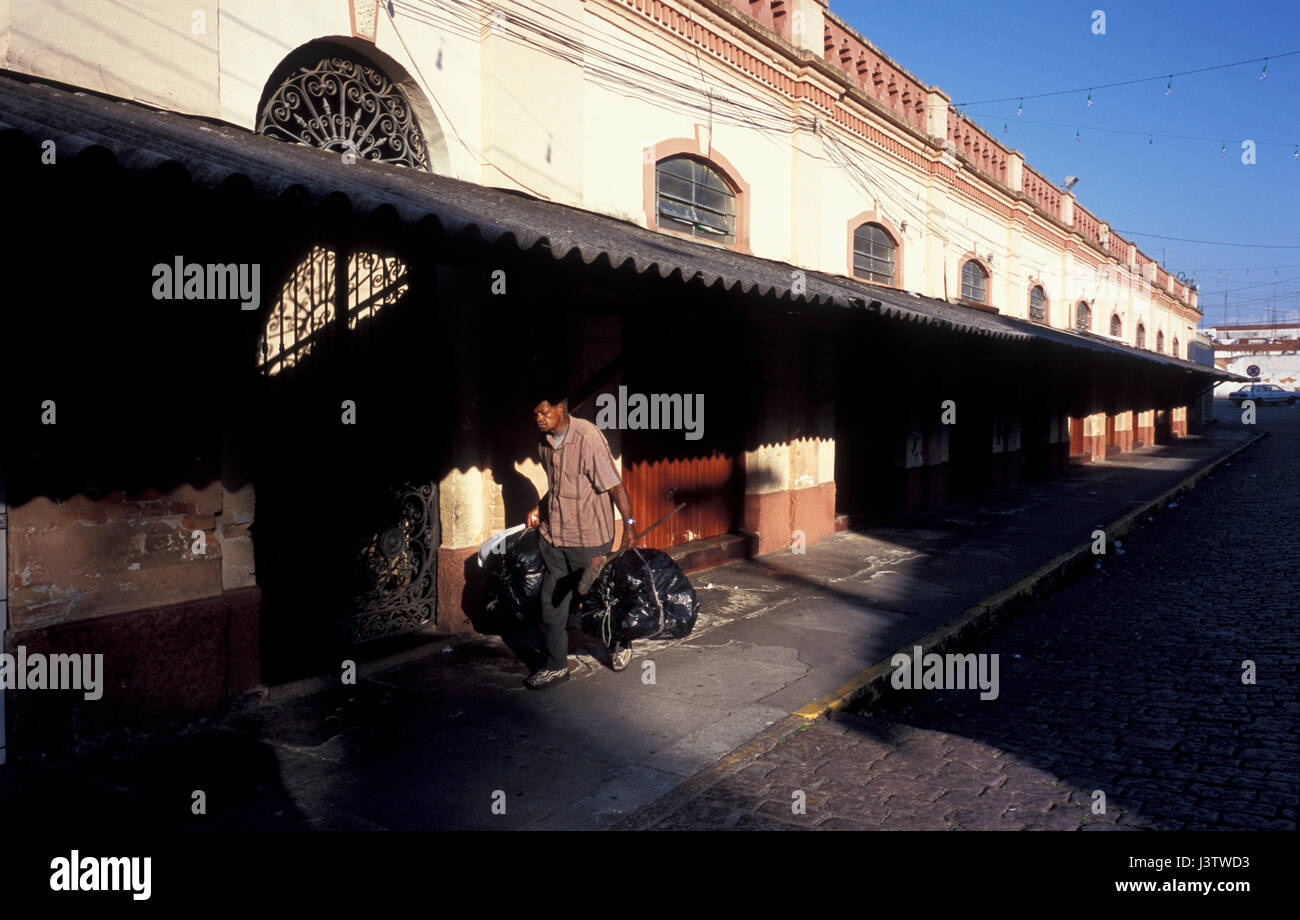 day laborer carrying trash bags after daily market in Brazil Stock Photo