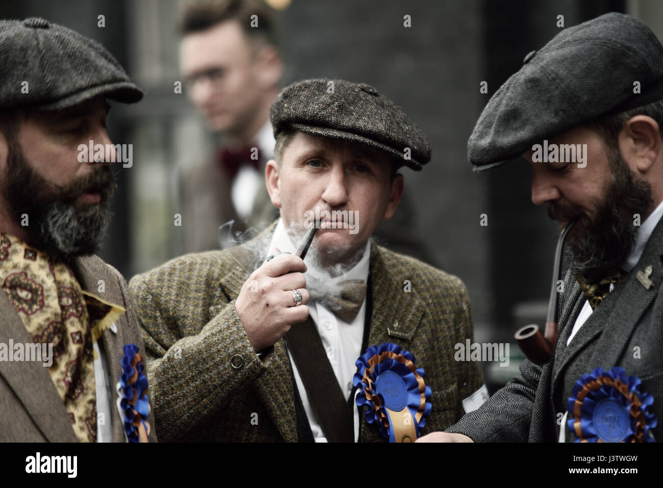 Tweed Run participants in London smoking pipes before mounting up Stock Photo