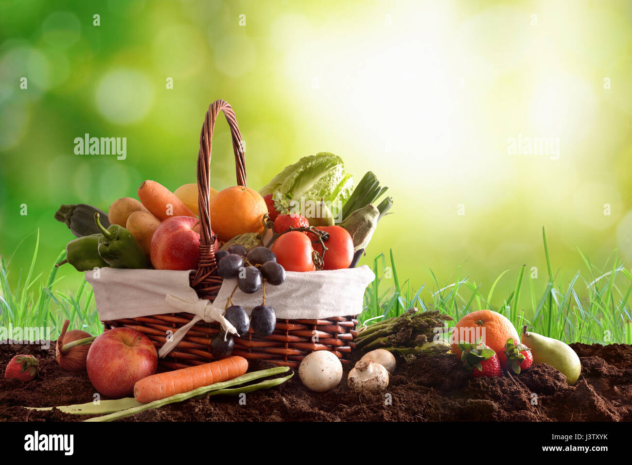 Assortment of fruits and vegetables in a wicker basket on soli and ...