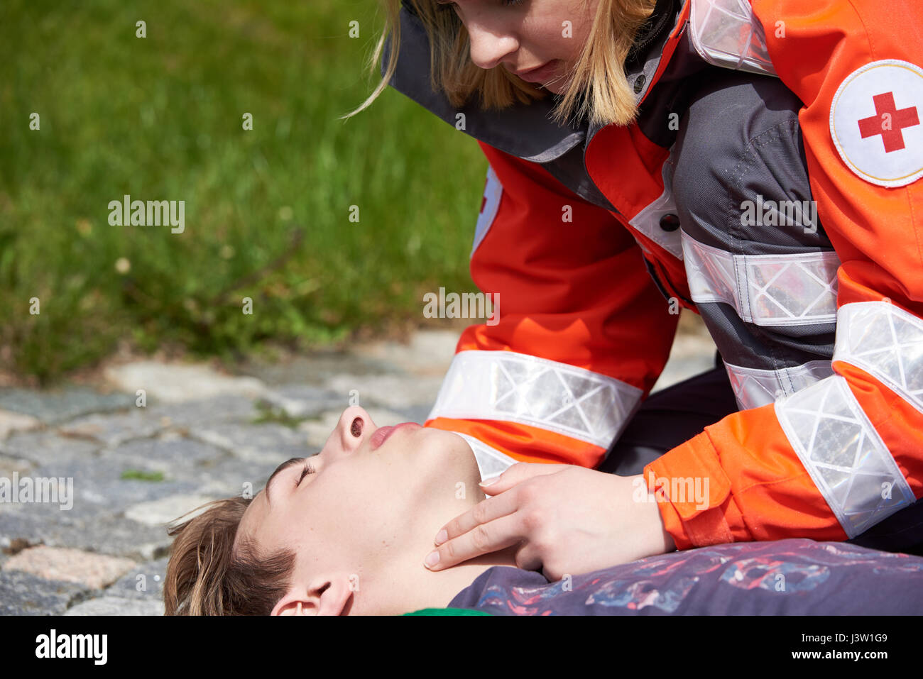 Professional paramedic giving unconscious young man first aid Stock Photo