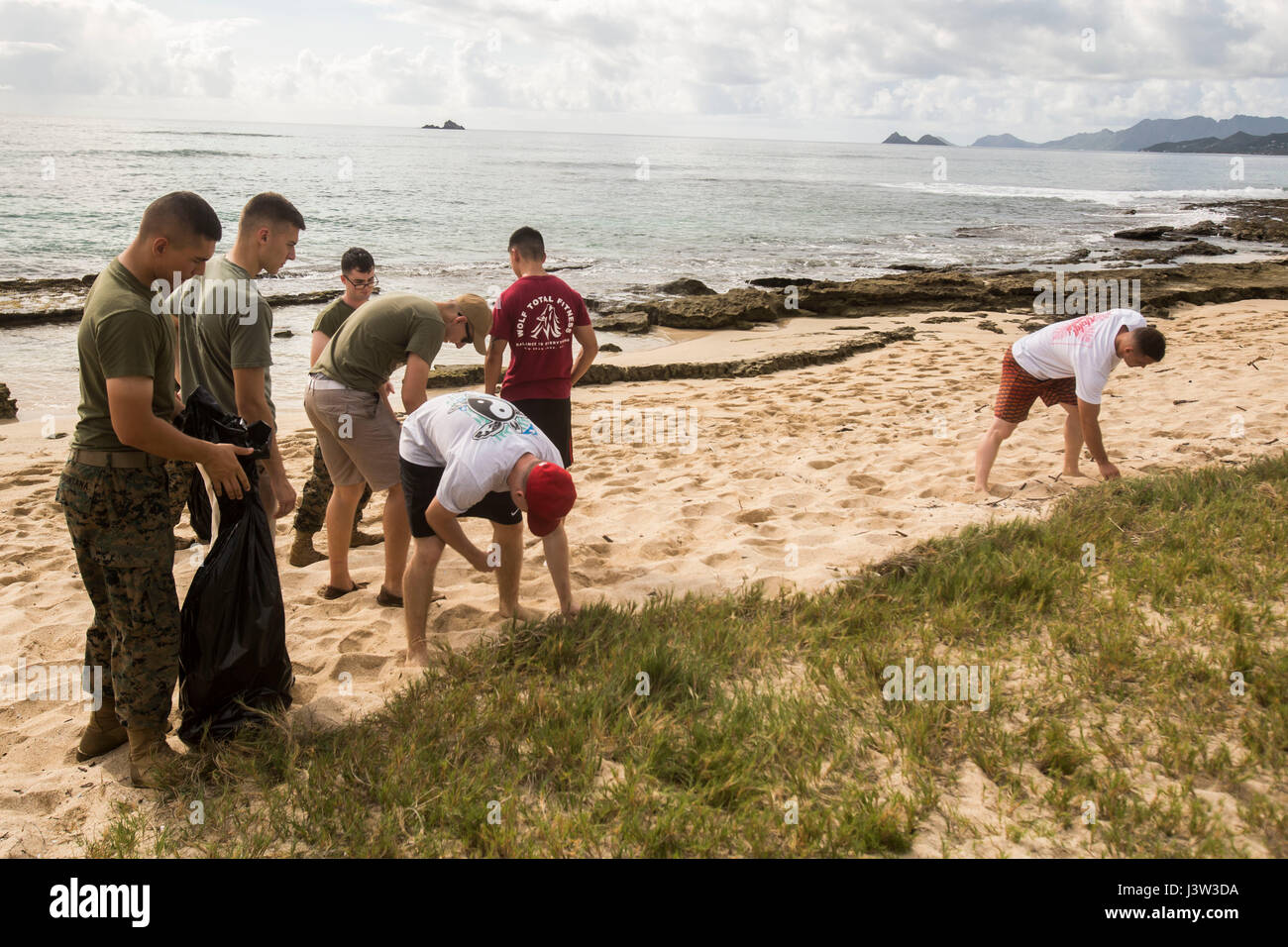 Marines with Marine Unmanned Aerial Vehicle Squadron 3 pick up trash during a base wide cleanup at Pyramid Rock beach aboard Marine Corps Base Hawaii on April 20, 2017. The semiannual cleanup event, “Malama Ka Aina,” is dedicated to cleaning MCB Hawaii, Pu’uola Rifle Range, Marine Corps Training Area Bellows, and Camp Smith. Malama Ka Aina is Hawaiian for “care for the land,” where Marines and Sailors from various units aboard MCB Hawaii work together to help keep each military installation litter free. (U.S. Marine Corps photo by Lance Cpl. Isabelo Tabanguil) Stock Photo