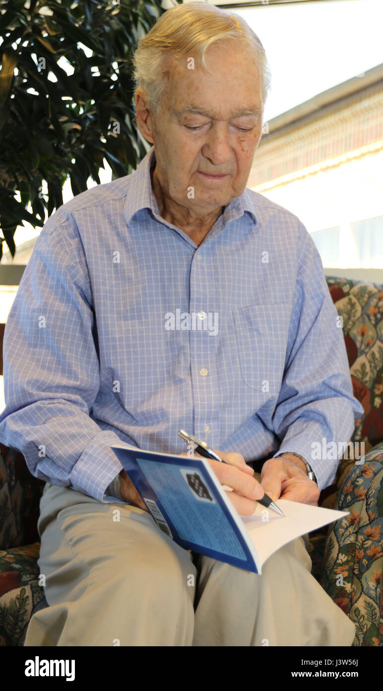 Claude Hodges, a 99th Infantry Division veteran who served during the Battle of the Bulge and is currently a resident at the Virginia Veterans Care Center in Roanoke, Virginia, autographs a copy of, “Battle Baby at the Bulge: The POW Experience of Claude Hodges,” by Col. Greg Eanes. Maj. Gen. Troy D. Kok, commanding general of the U.S. Army Reserve’s 99th Regional Support Command, visited Hodges and other veterans at the center April 28. Stock Photo