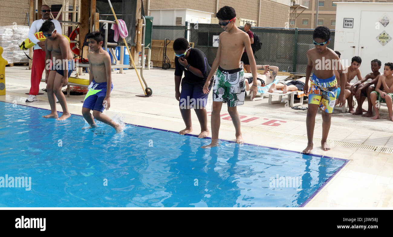 Boy Scouts of Troop 965 Kuwait jump feet first into the swimming pool