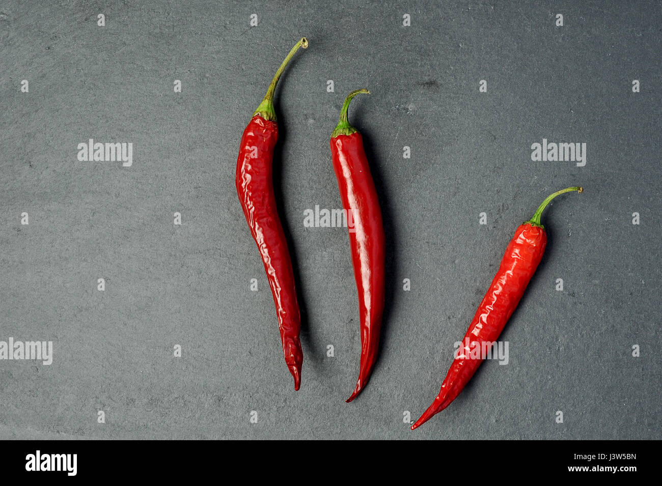red chili peppers on black background, top view Stock Photo - Alamy