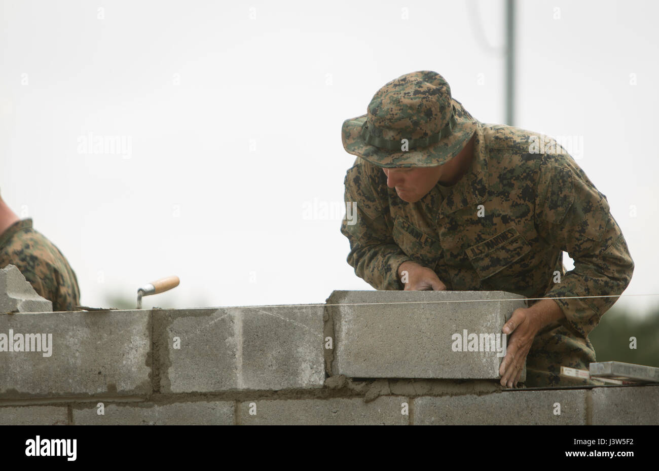 CAMP LEJEUNE, N.C.- Sgt. Chad R. Stanley, a heavy equipment foreman with the Logistics Combat Element, Special Purpose Marine Air-Ground Task Force - Southern Command, lays a concrete block while building the wall of a simulated schoolhouse during General Exercise 2 at Marine Corps Base Camp Lejeune, North Carolina, April 28, 2017. The Marines simulated construction of a schoolhouse in preparation for infrastructure improvement projects scheduled during their upcoming deployment to Central America. (U.S. Marine Corps photo by Sgt. Ian Leones) Stock Photo