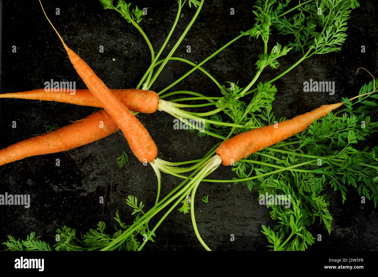 carrots arrangement on black background, top view Stock Photo