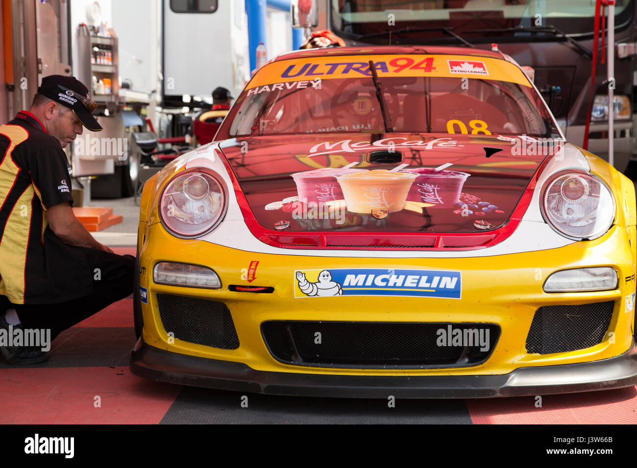 Crew Member Checking Tire on Porsche GT3 Cup Challenge 2014 Car Stock Photo