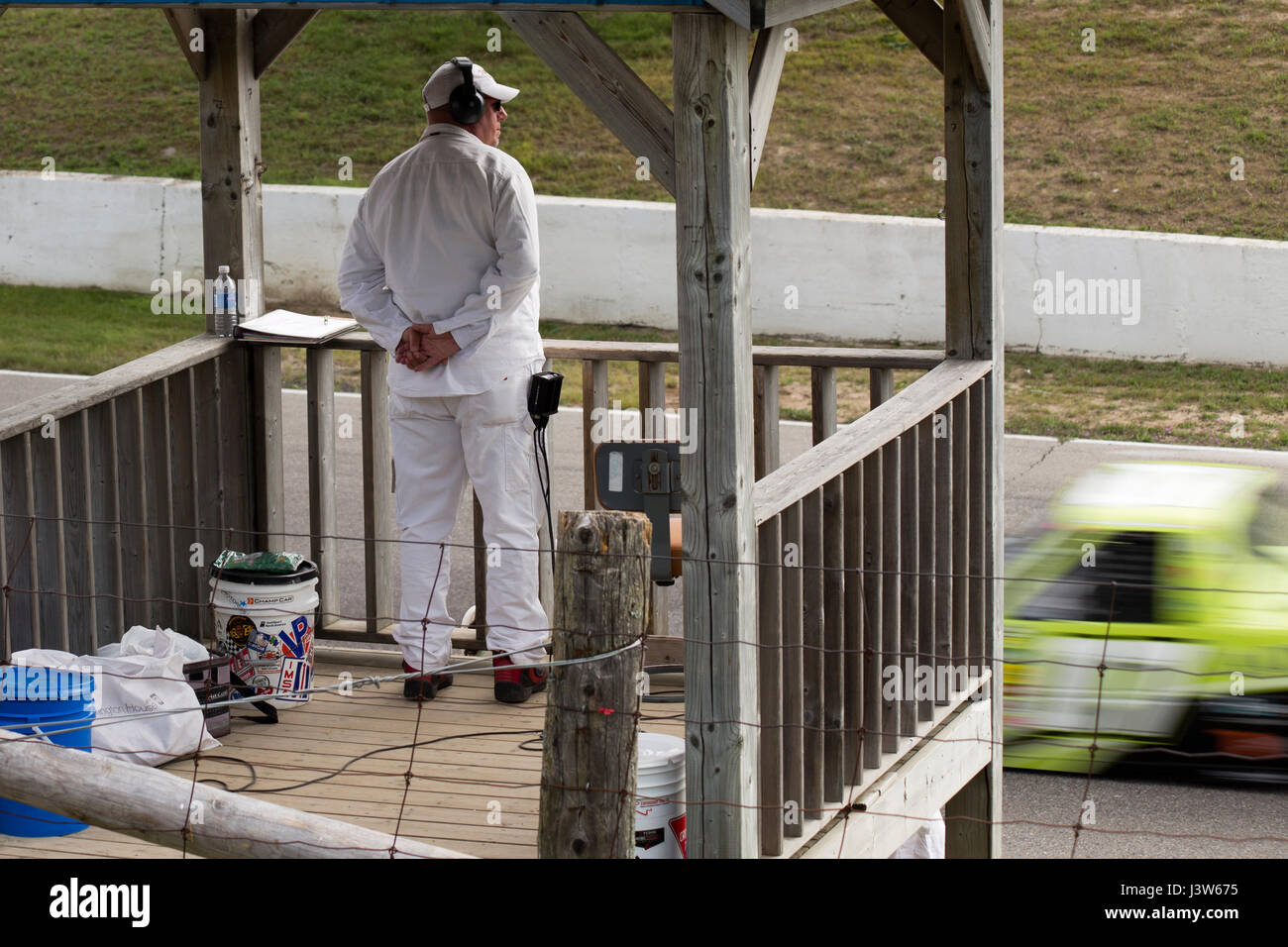 Race Official Watching Track and Truck in Motion Blur at Chevrolet Silverado 250 Truck Series Stock Photo