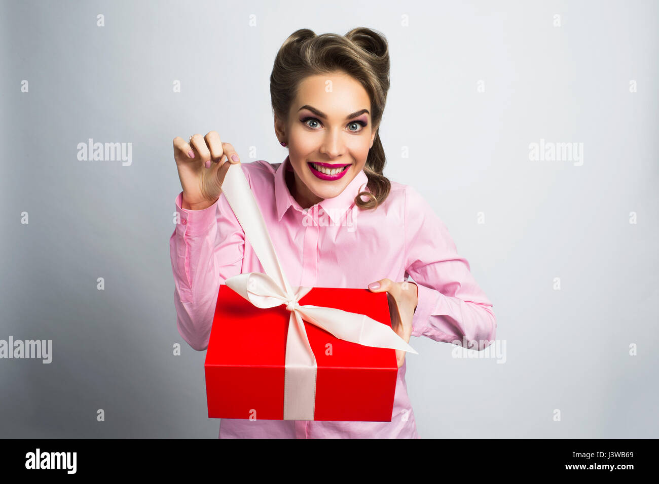 Happy beautiful funny woman unpacks gift Stock Photo