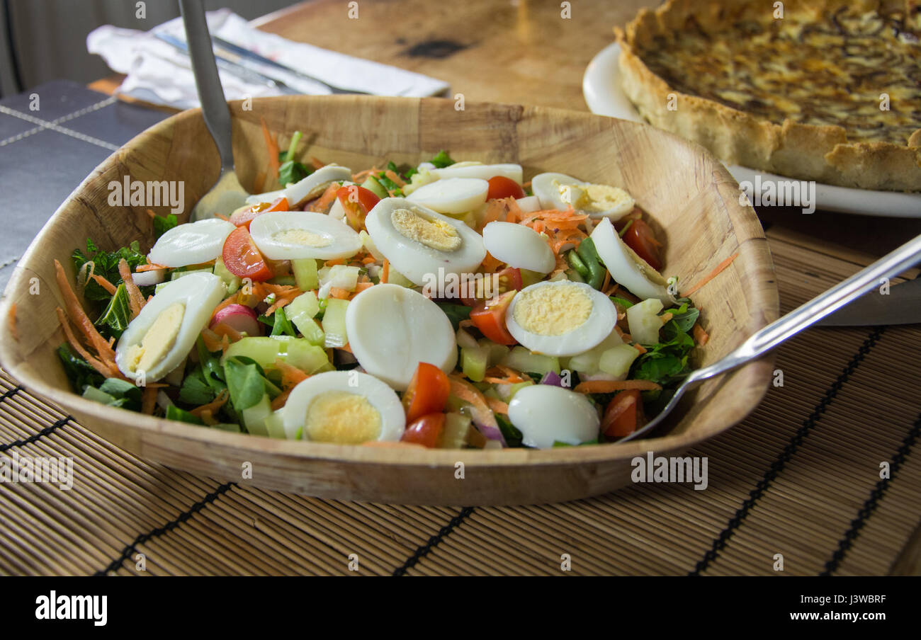 A bowl of egg salad. Made up of hard boiled egg, lettuce, tomato