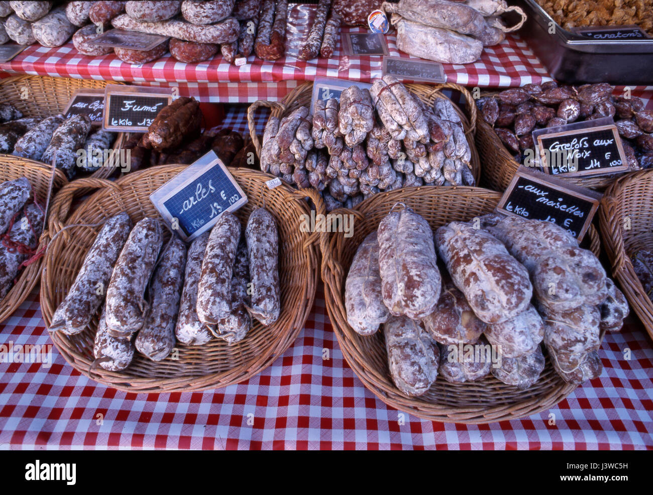Varieties of rustic French Saucission on sale priced in Euros on market stall in central traditional Beaune town market, Beaune, Côte d'Or, France. Stock Photo