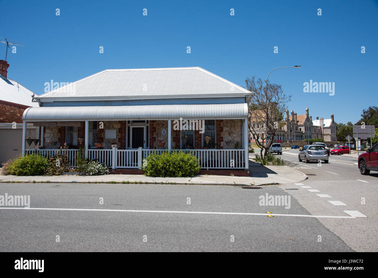 Fremantle road with quaint limestone cottage and the Arts Centre in the background with traffic in downtown Fremantle, Western Australia. Stock Photo