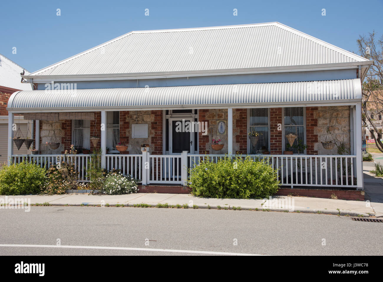 Small limestone cottage with hanging planters in the historic town of Fremantle, Western Australia. Stock Photo