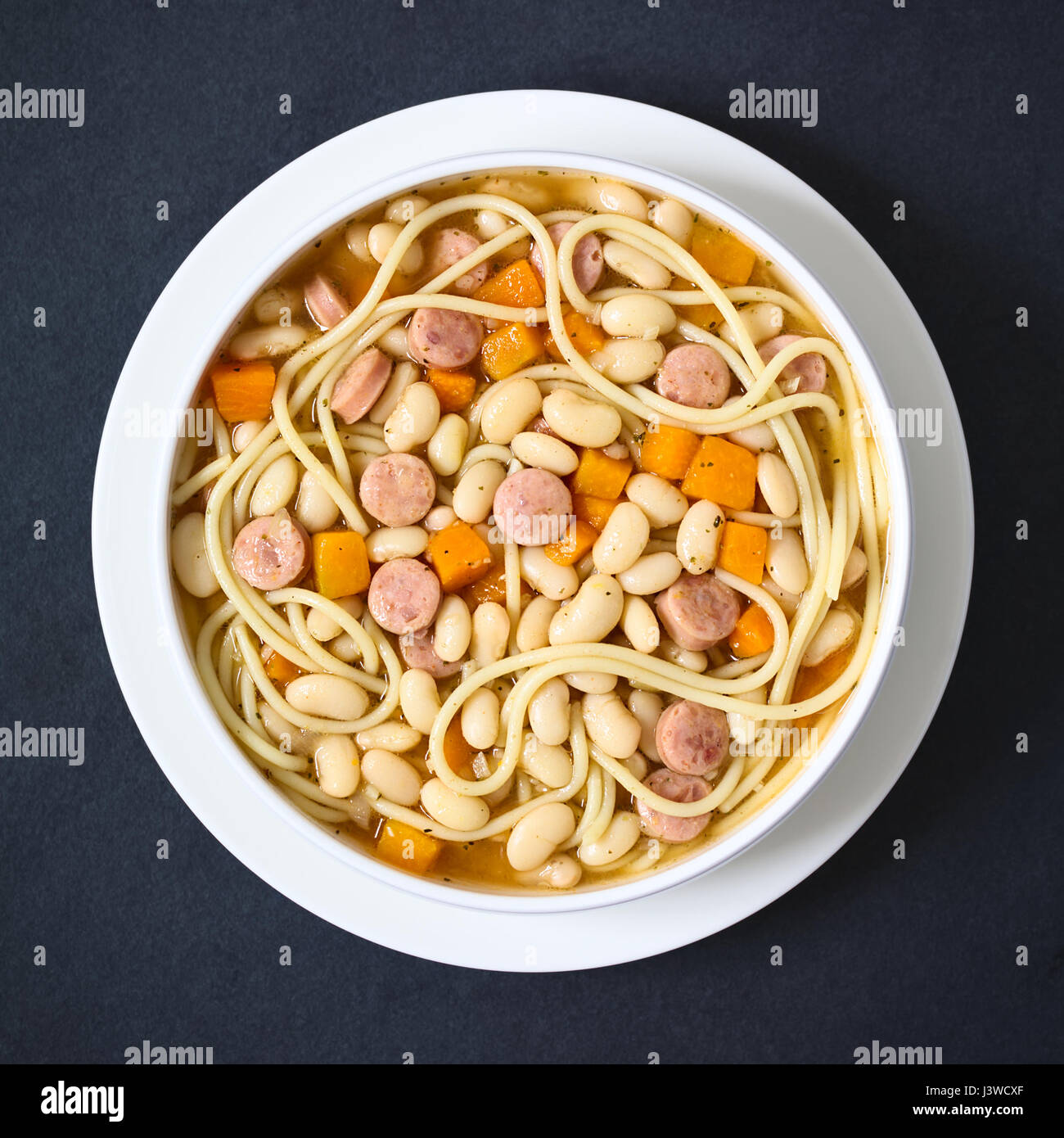 Chilean traditional Porotos con Riendas (beans with reins) dish of cooked dried beans with pumpkin, onion, spaghetti and sausage Stock Photo