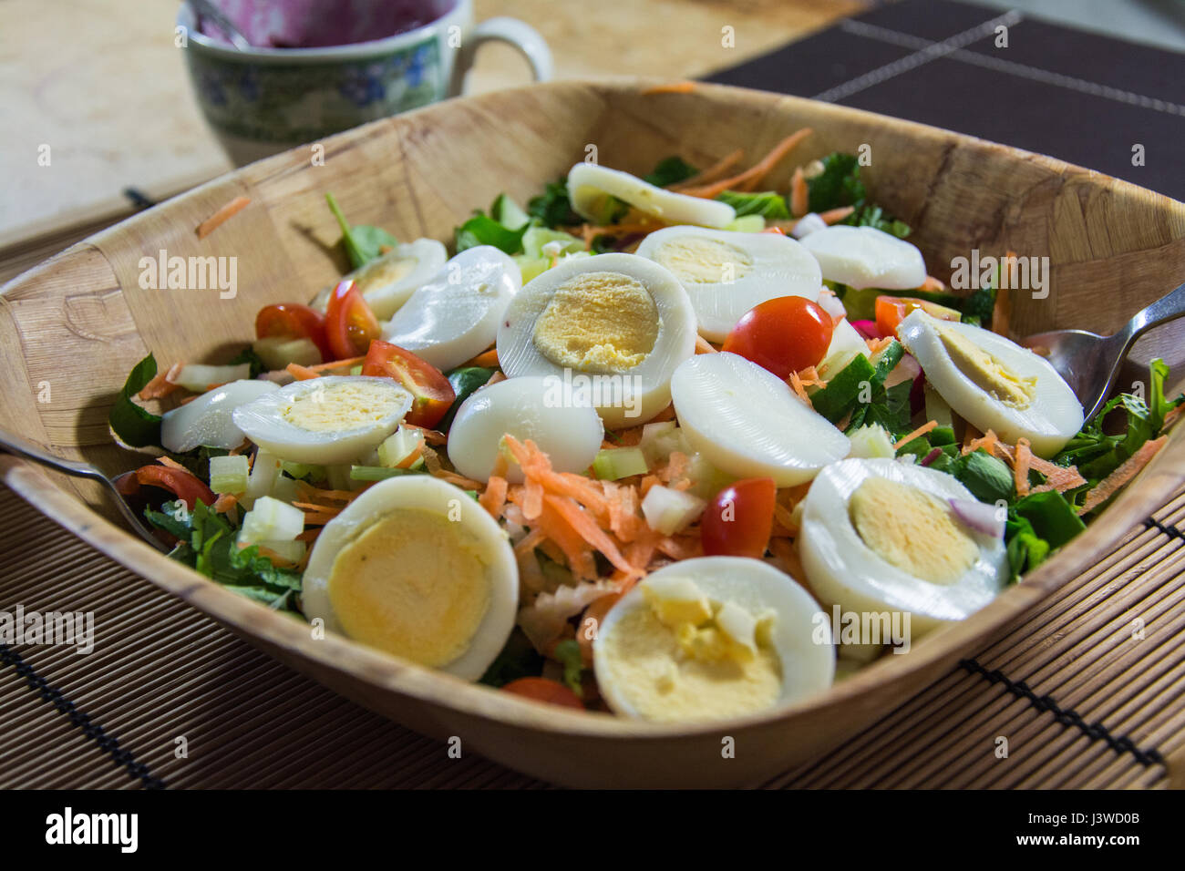A bowl of egg salad. Made up of hard boiled egg, lettuce, tomato
