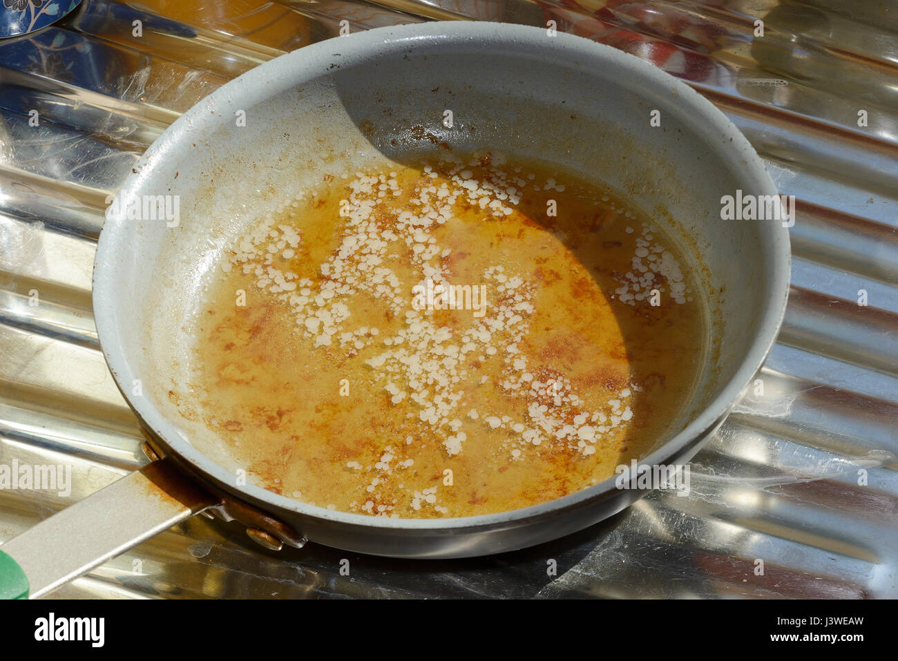 Oil fat and water in a frying pan Stock Photo