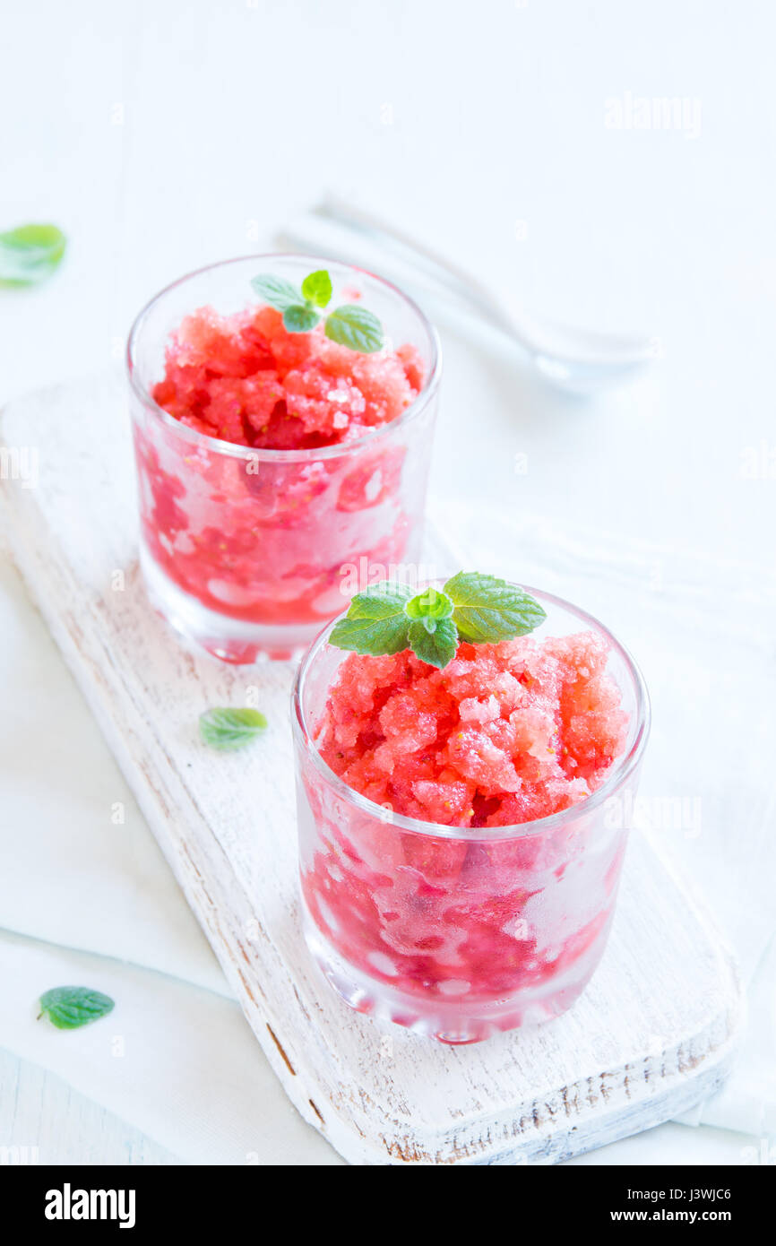 Strawberry granita with mint (frozen dessert) in portion glasses on