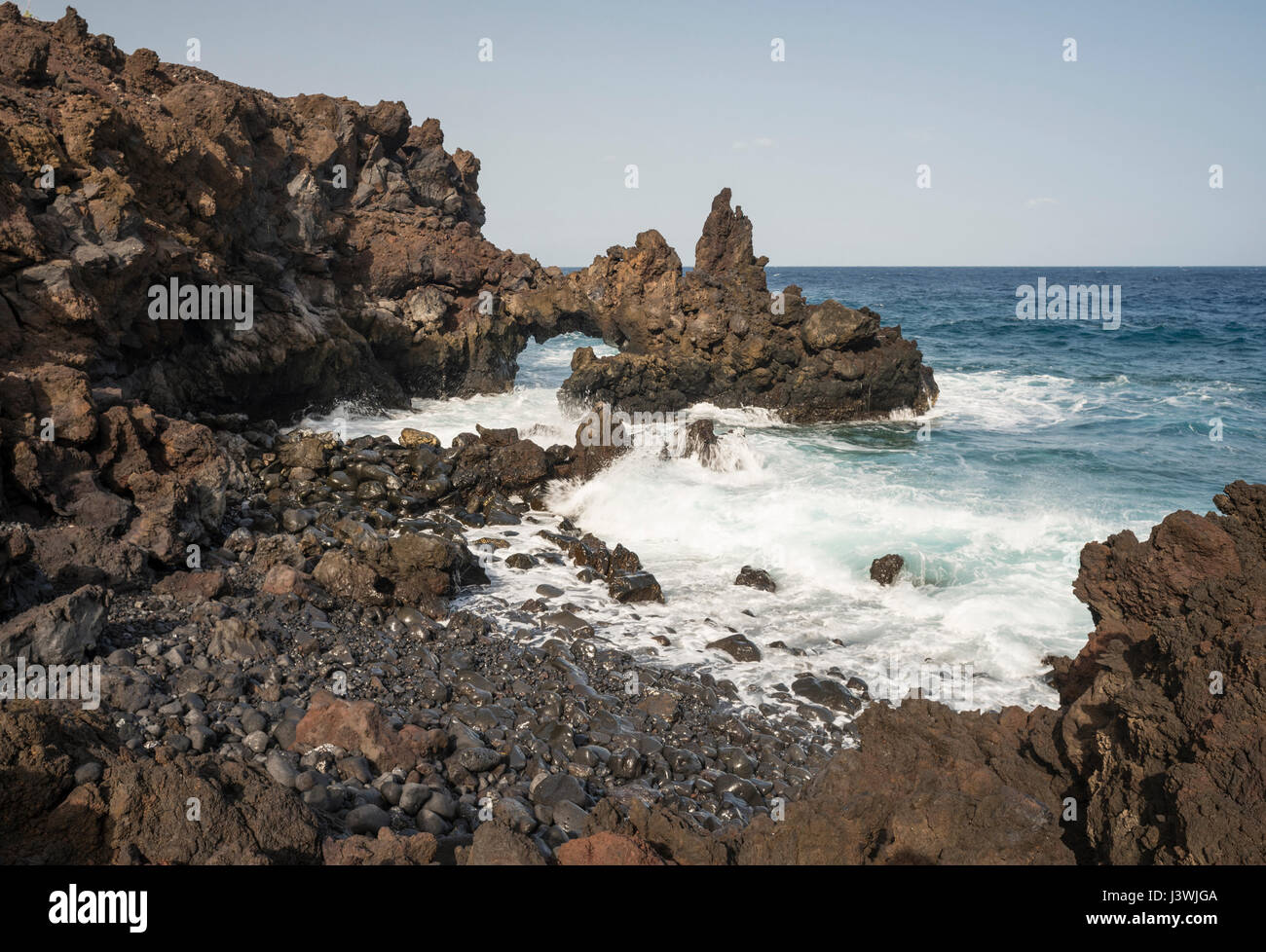Coastal erosion caused by strong wave action has produced a sea arch near Tamaduste in north-eastern El Hierro, Canary Islands Stock Photo