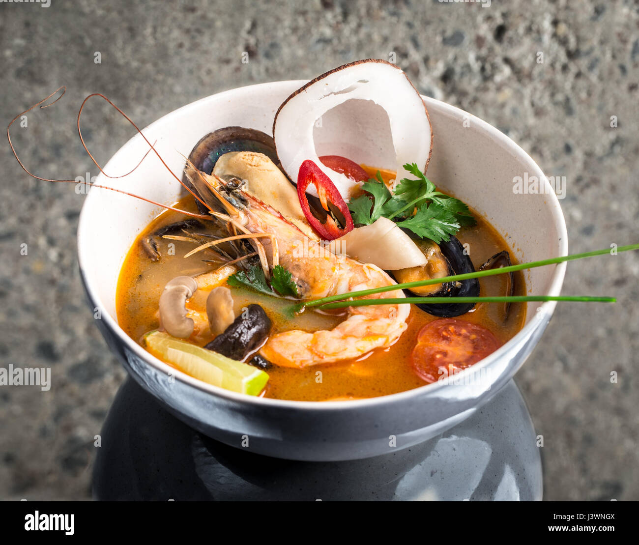 Tom Yum Goong thai soup over concrete background Stock Photo