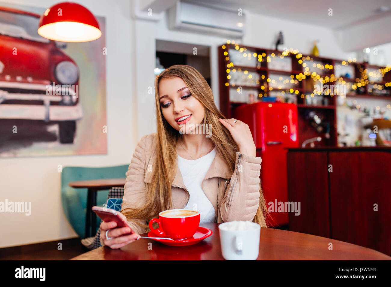 Happy female using smart phone while relaxing in cafe after walking ...