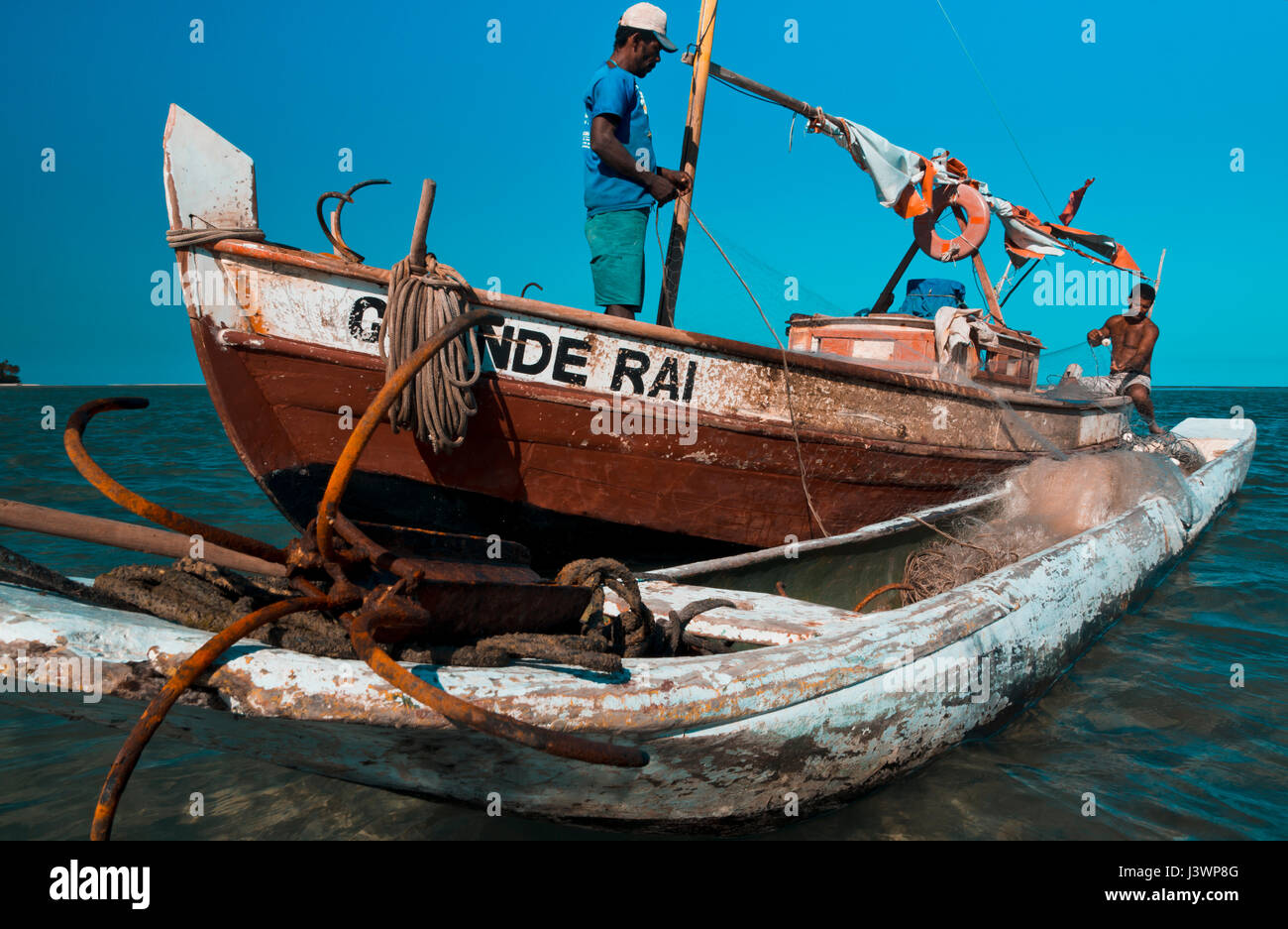 two fishermen in a boat offshore Boipeba, Bahia, Brazil Stock Photo