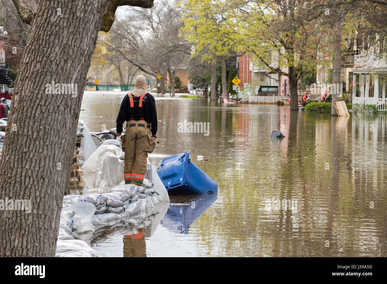 Montreal, Canada. 8th May, 2017. Rescue worker evaluates the situation as flooding hits Cousineau street Credit: Marc Bruxelle/Alamy Live News Stock Photo