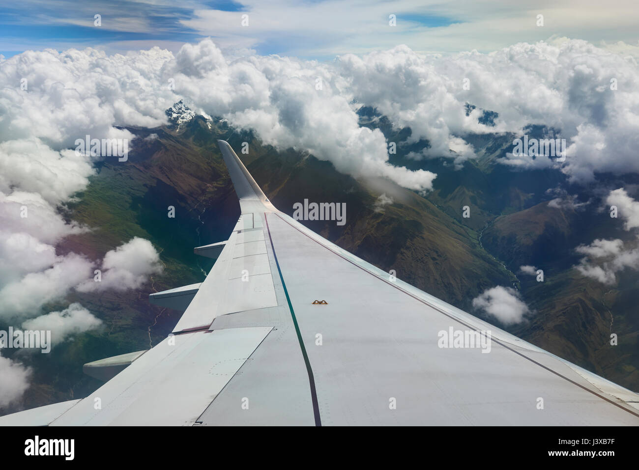 Airplane wing under mountain landscape of Andes. Traveling in South America Stock Photo