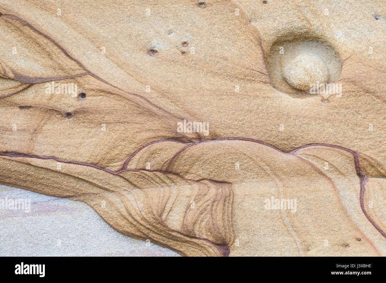 An abstract shape in a sandstone cliff that resembles a landscape. Stock Photo