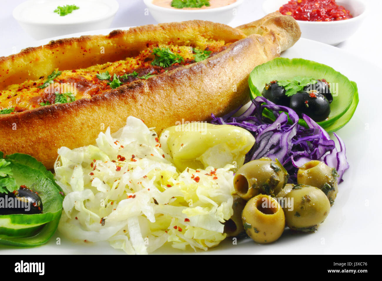 turkish pide with cheese, iceberg salad, olives, red cabbage and cucumber Stock Photo