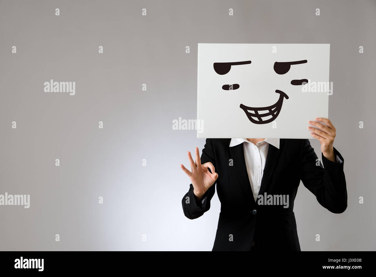 proud face expression drawing on blank white billboard with okay hand gesture. isolated on gray background. business office company concept. Stock Photo