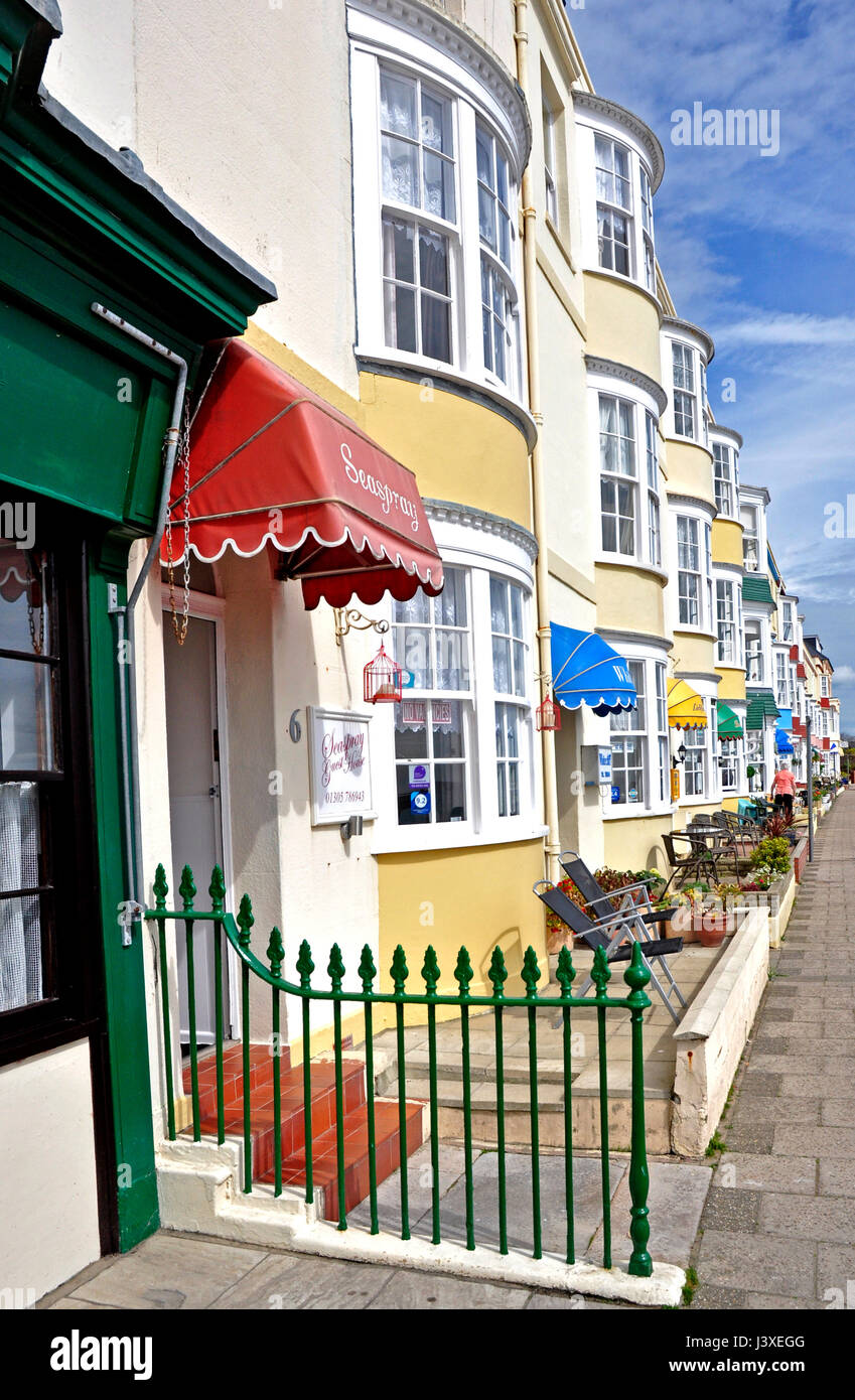 Terraced row of small seafront hotels Weymputh Dorset - georgian period bow windows - pastel colours - sunlight  - blue sky Stock Photo