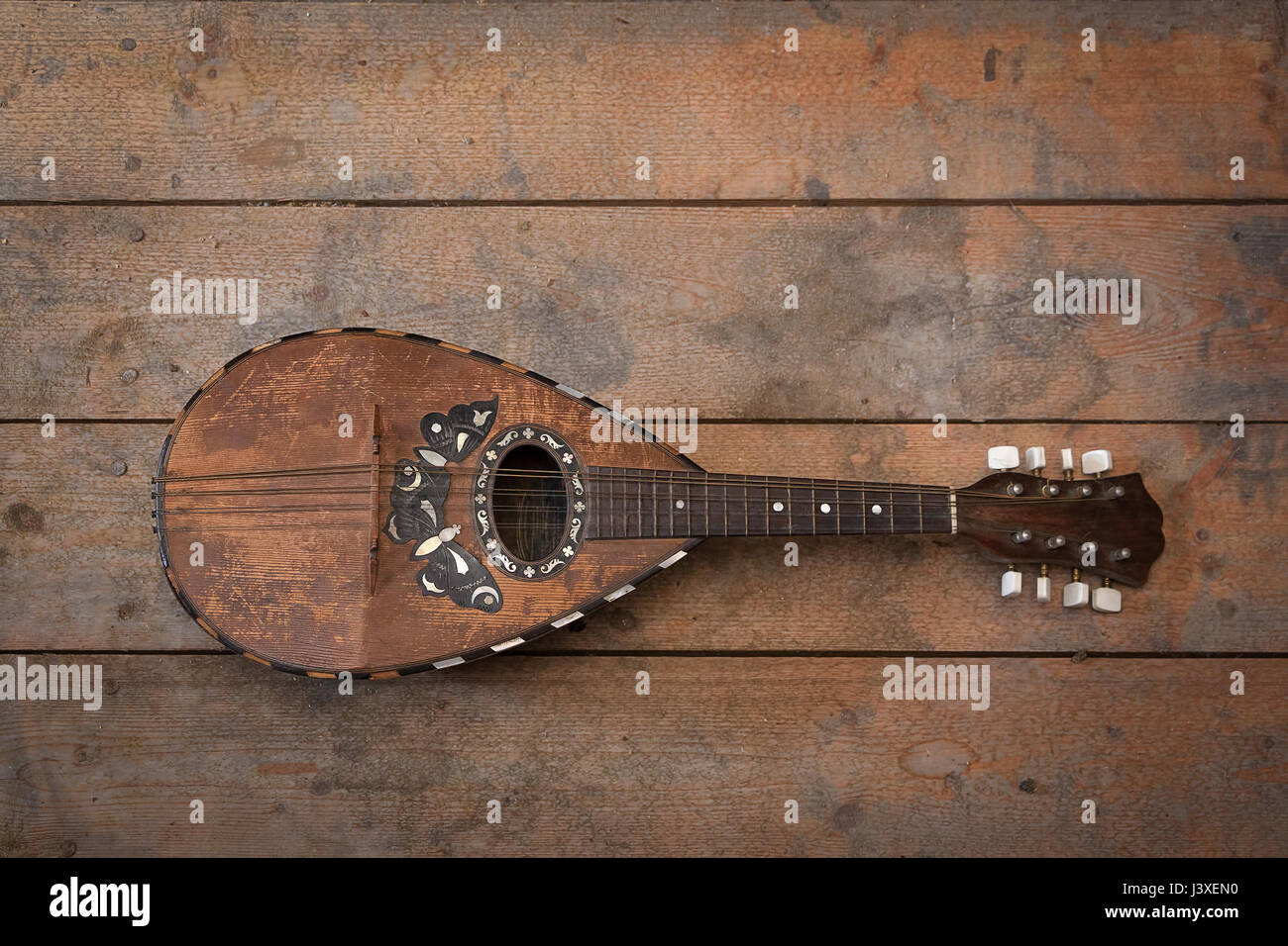Old grunge mandolin on wooden wall Stock Photo