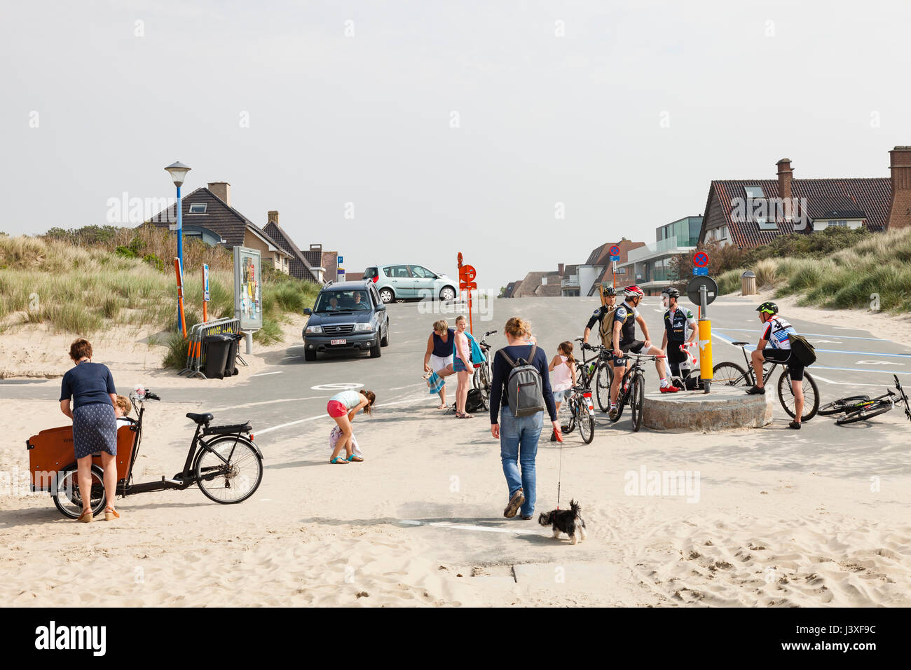 Koksijde, Belgium - Tourists and cyclers on the edge of the beach in Sint-André near Koksijde Stock Photo