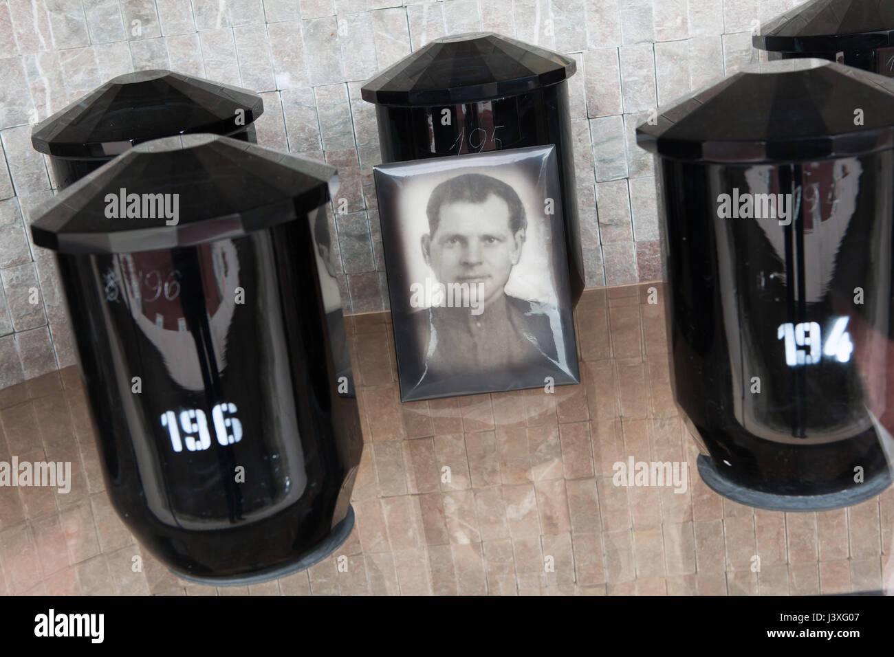 Funerary urns of Bohemian crystal glass containing the ashes of Soviet military officers fallen during World War II preserved on the ground of the Soviet War Memorial at the Central Cemetery in Brno, Czech Republic. Photograph of an unknown Red Army military officer are seen in the picture. Stock Photo