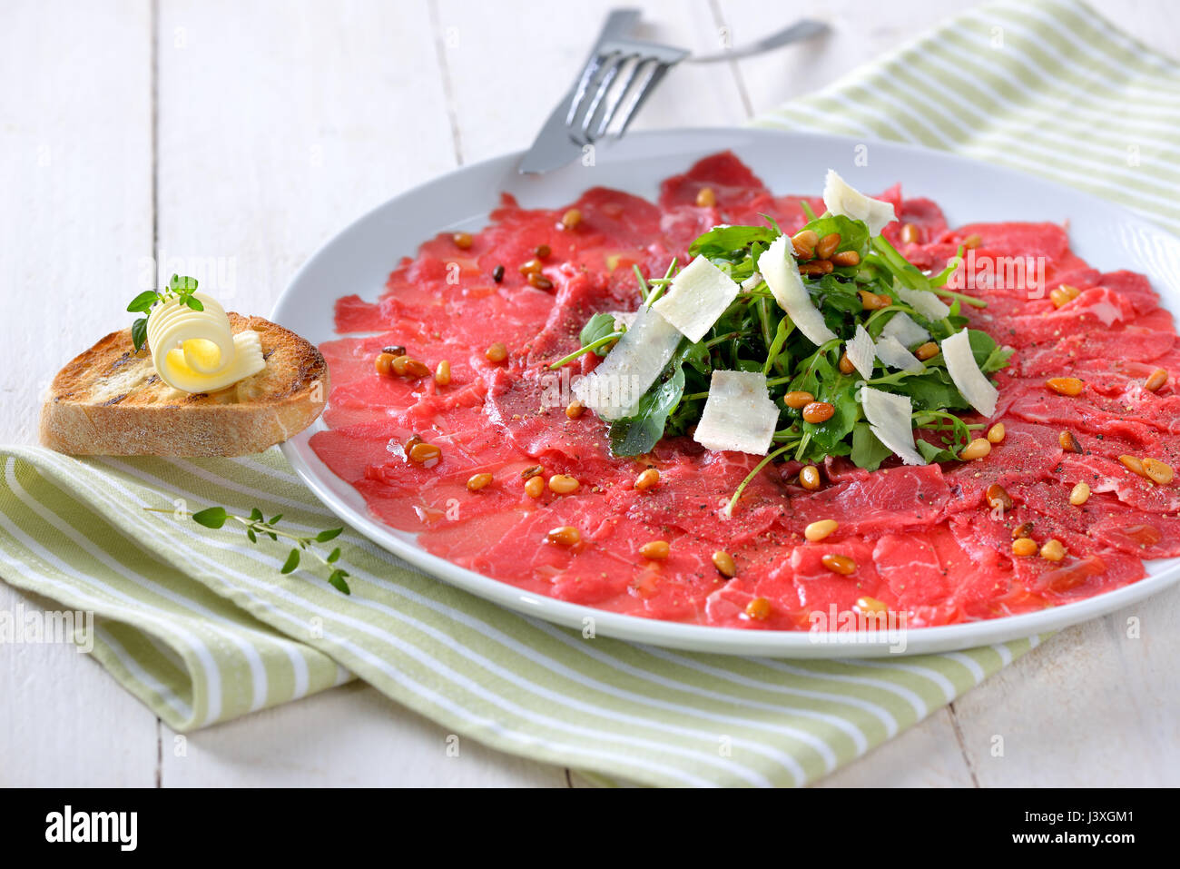 Delicious beef carpaccio with rocket salad, parmesan cheese and roasted