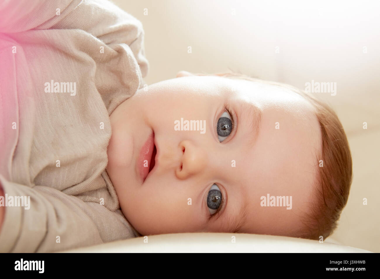 Close up portrait of blue eyed baby boy lying on sofa Stock Photo
