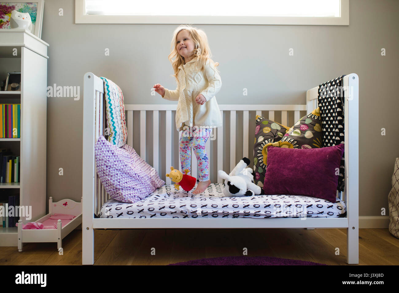 Girl jumping on day bed Stock Photo