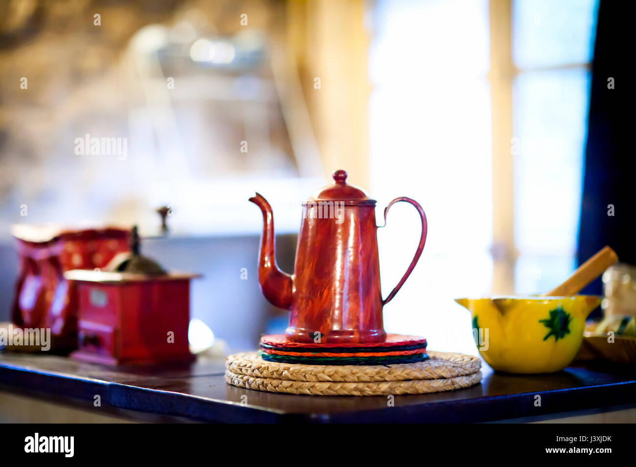 Traditional red coffee pot and coffee grinder on kitchen counter Stock Photo