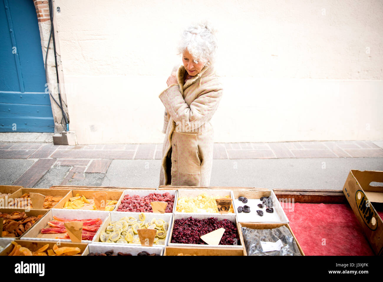 Mature female shopper looking at dried food at local french market Stock Photo