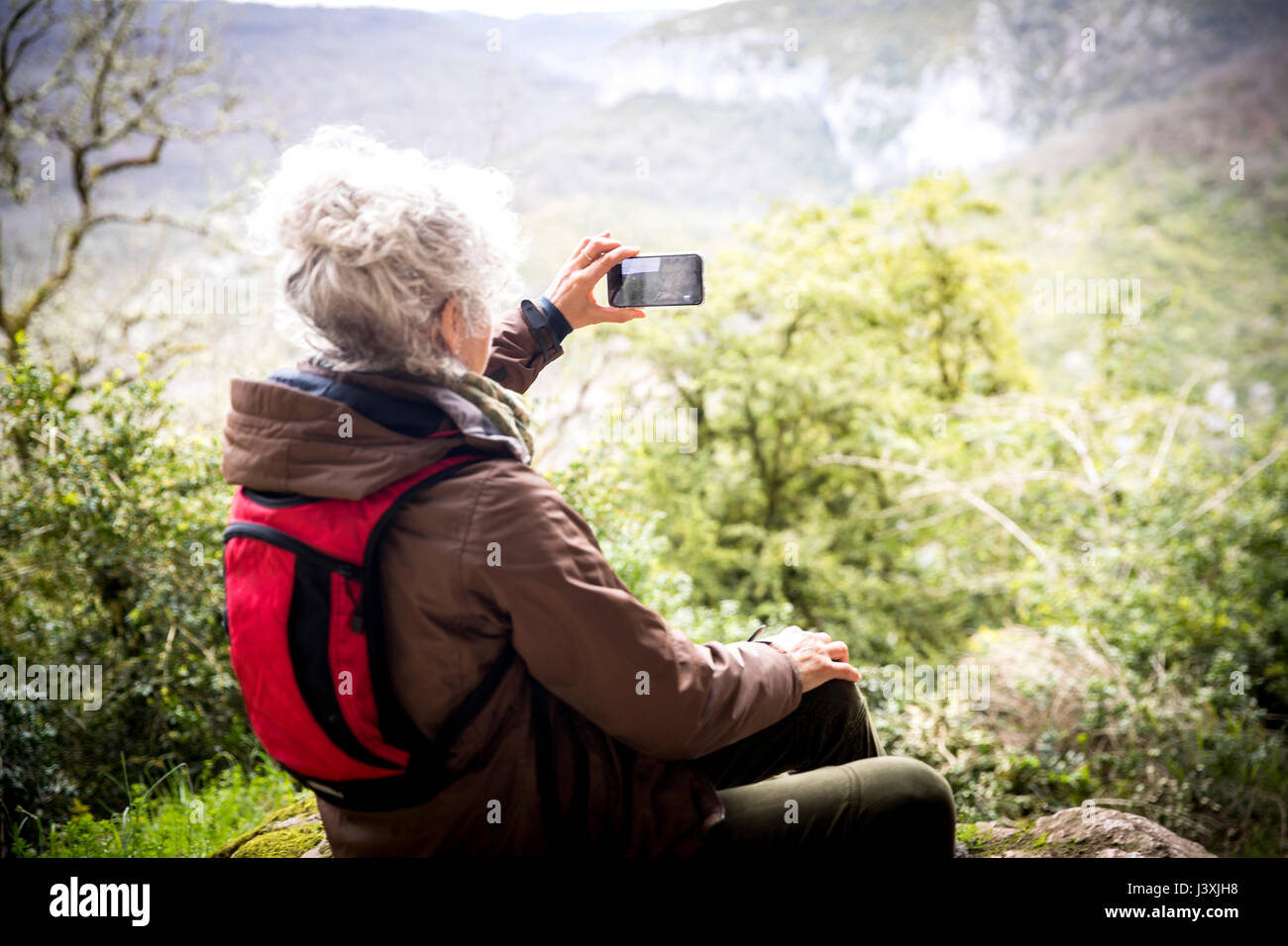Woman hiker photographing elevated view, Bruniquel, France Stock Photo