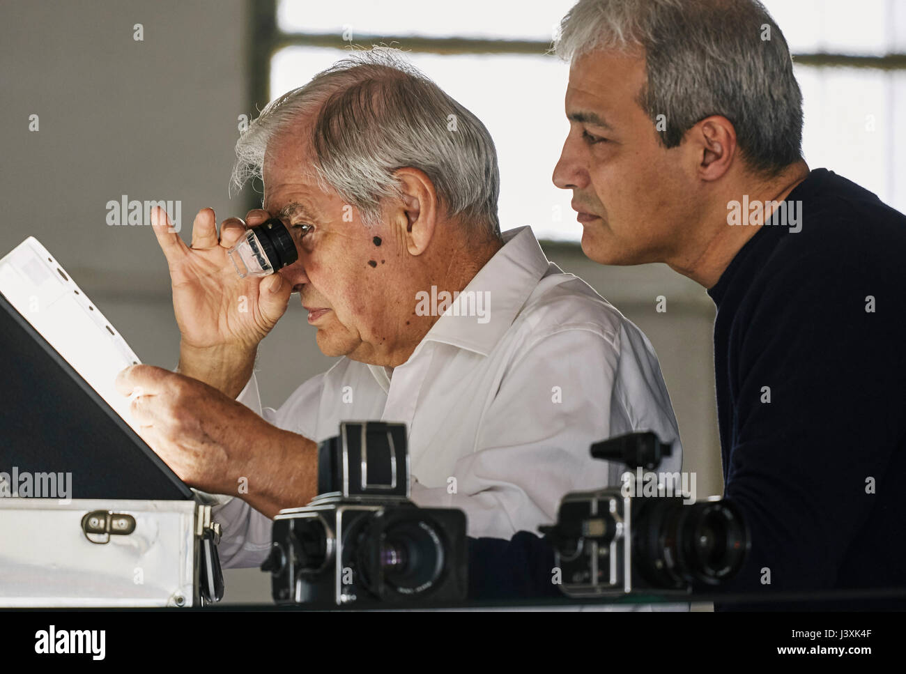 Father and son looking at sheet of film slides Stock Photo