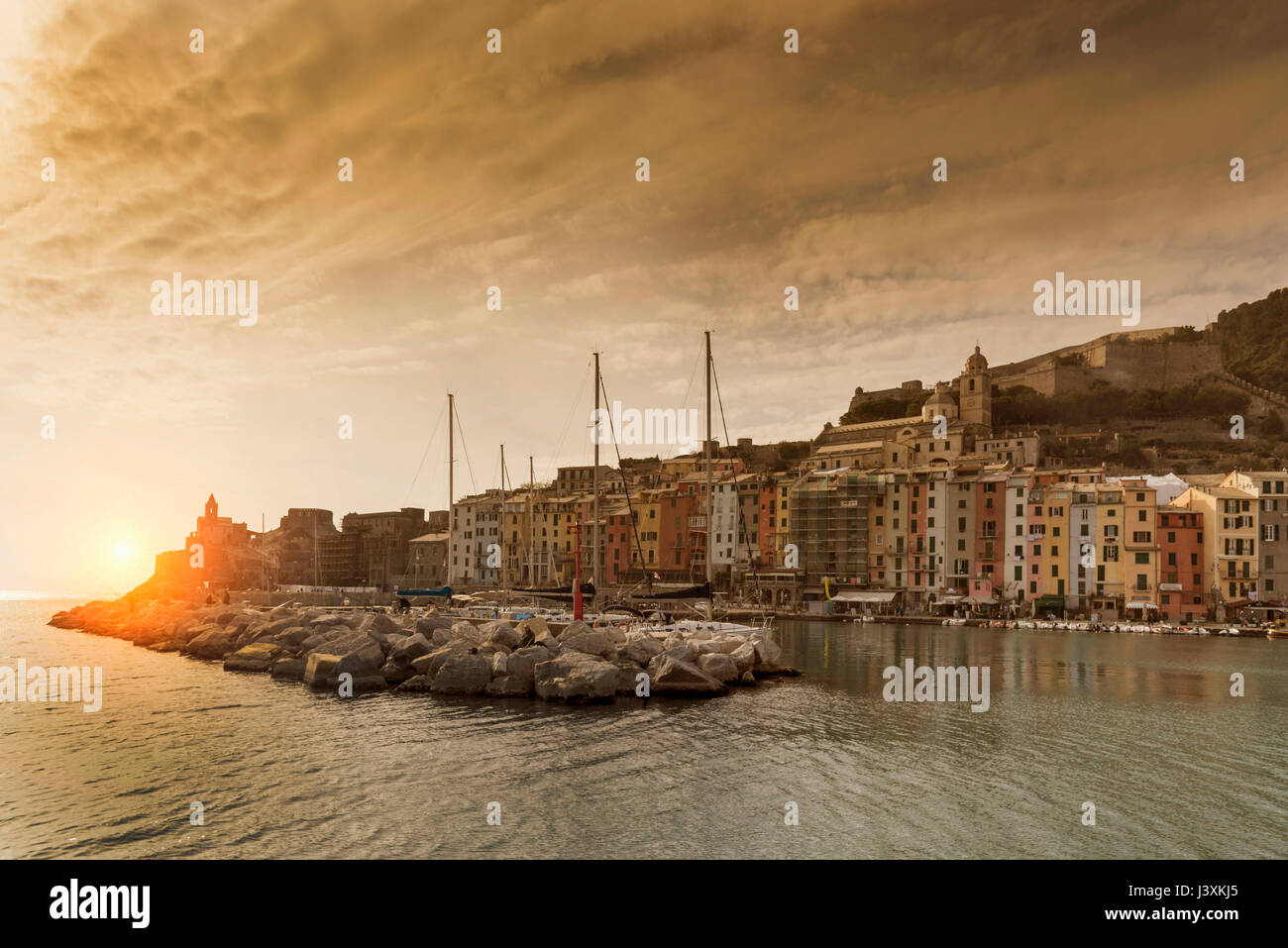 View of harbour and Church of St Peter on headland at sunset, Porto Venere, Liguria, Italy Stock Photo