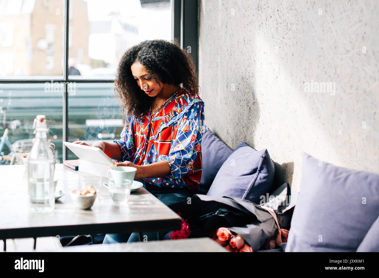 Mid adult woman using digital tablet in cafe Stock Photo