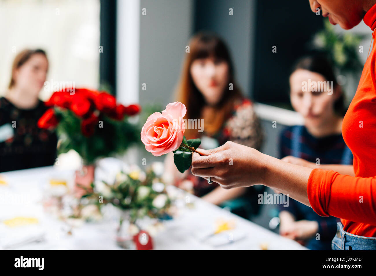 Florist showing rose to students in flower arranging Stock