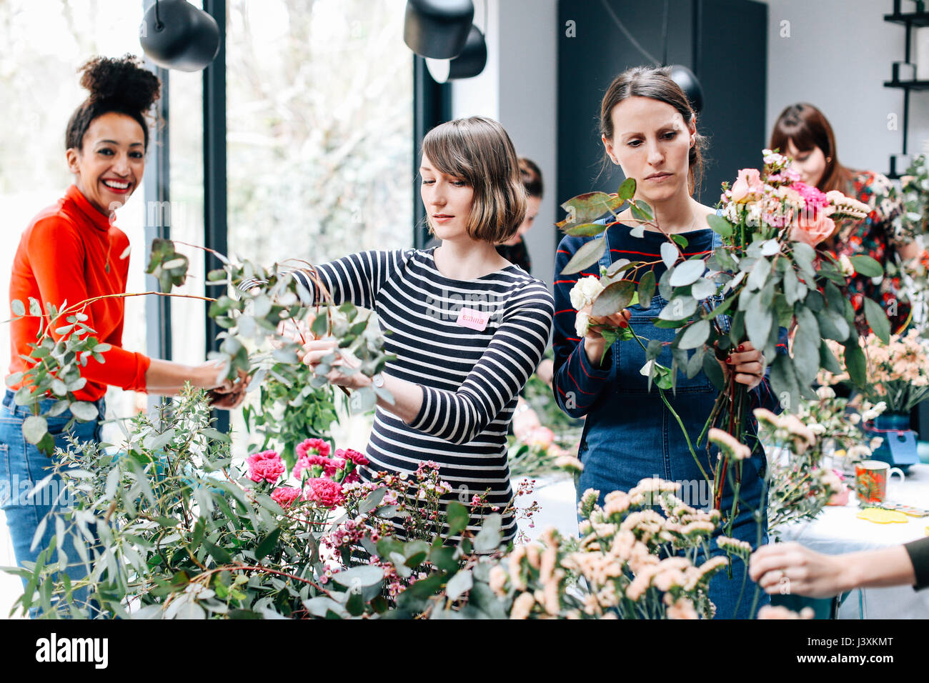 Florist students selecting cut flowers at flower arranging workshop Stock Photo