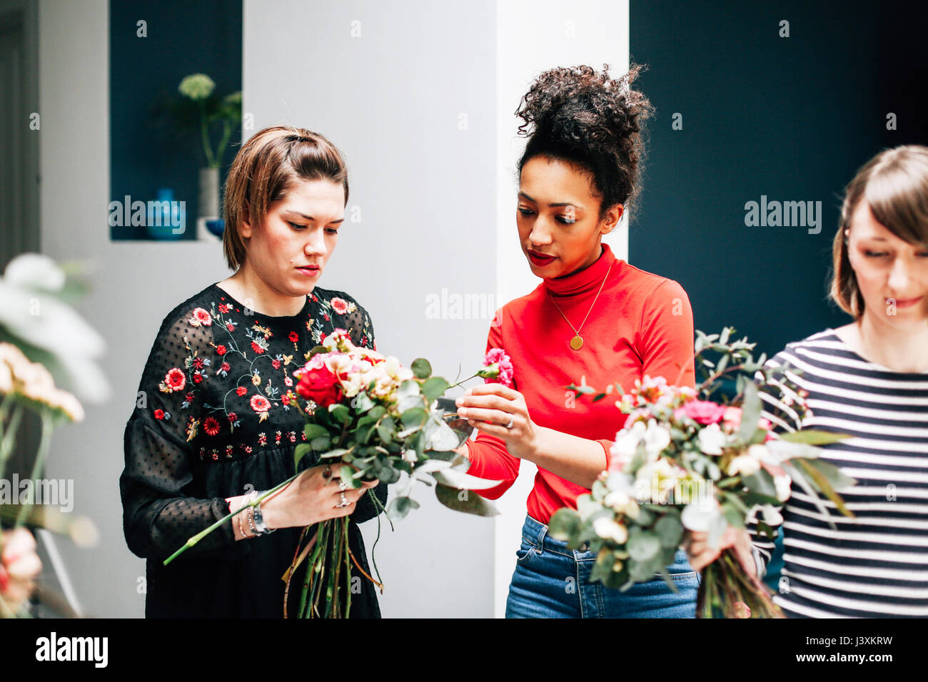 Florist students arranging bouquets at flower arranging Stock