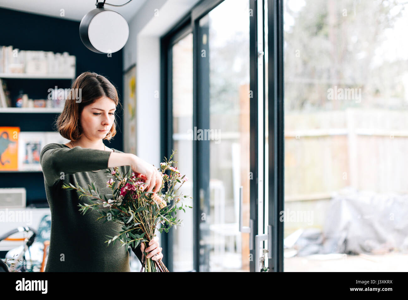 Florist student arranging bouquet at flower arranging Stock