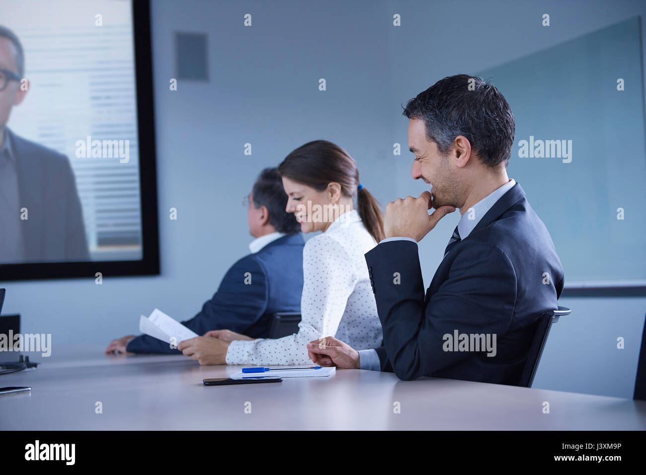 Businesswoman and man smirking during office conference call Stock Photo