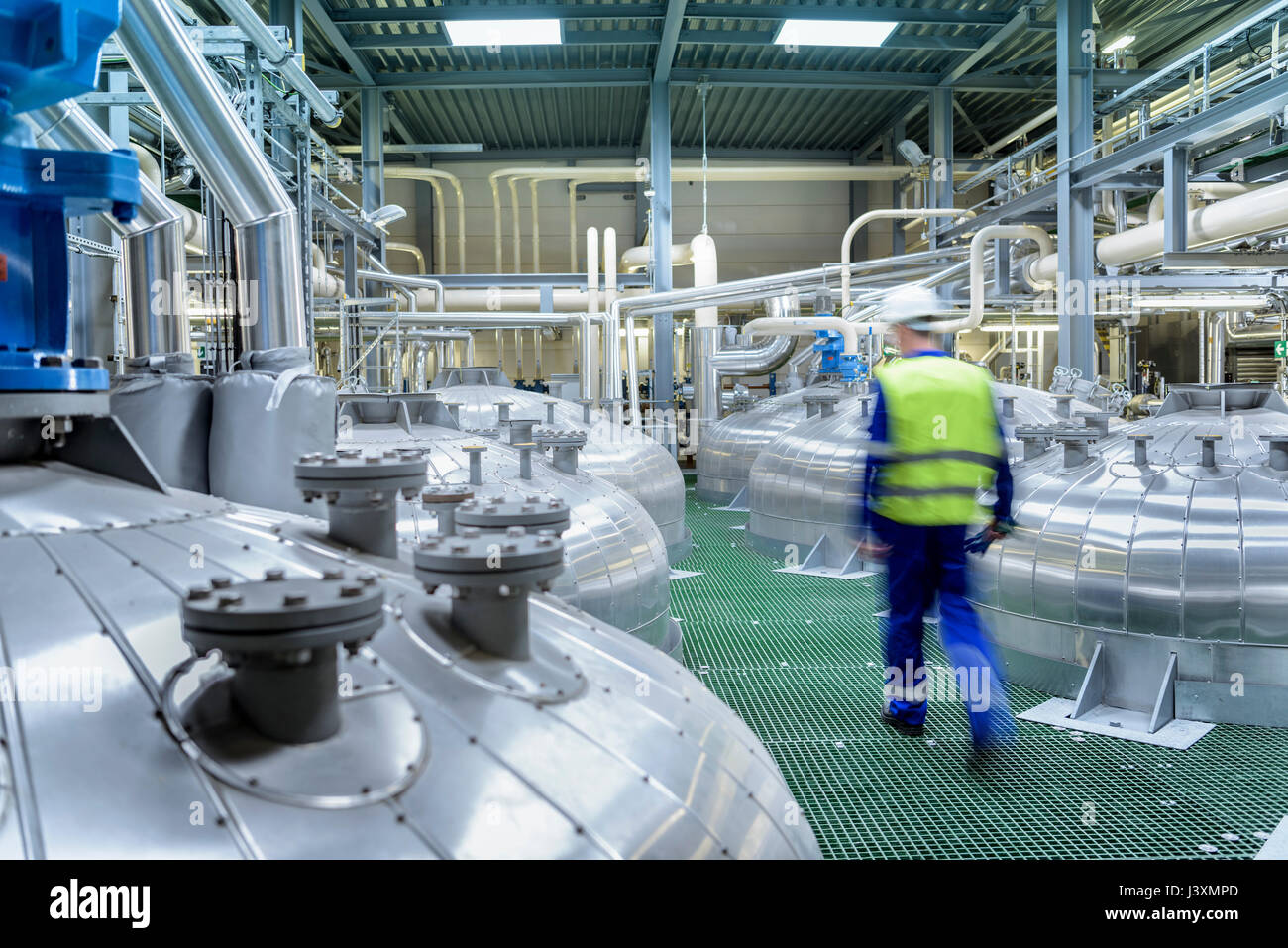 Worker with process machinery in oil blending factory Stock Photo