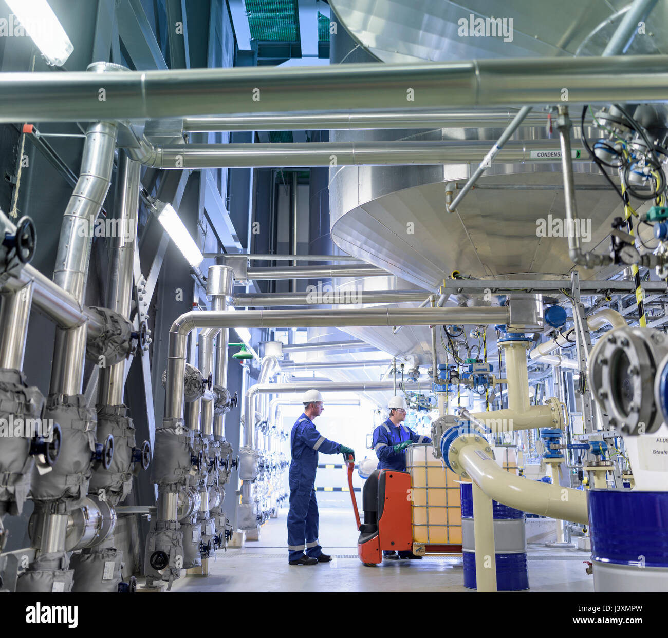Workers with process machinery in oil blending factory Stock Photo